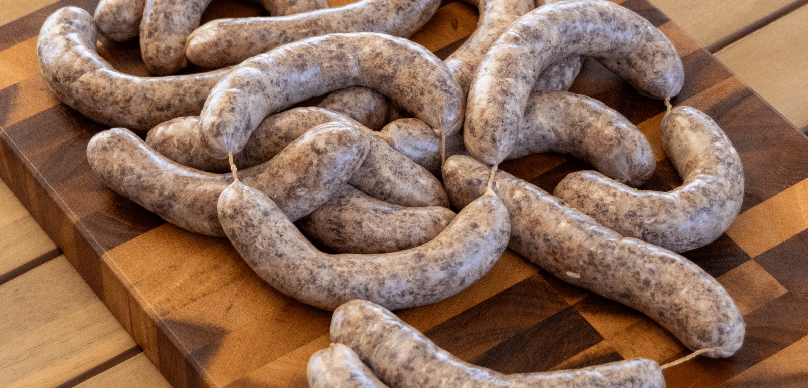 Raw sausages on a wooden cutting board
